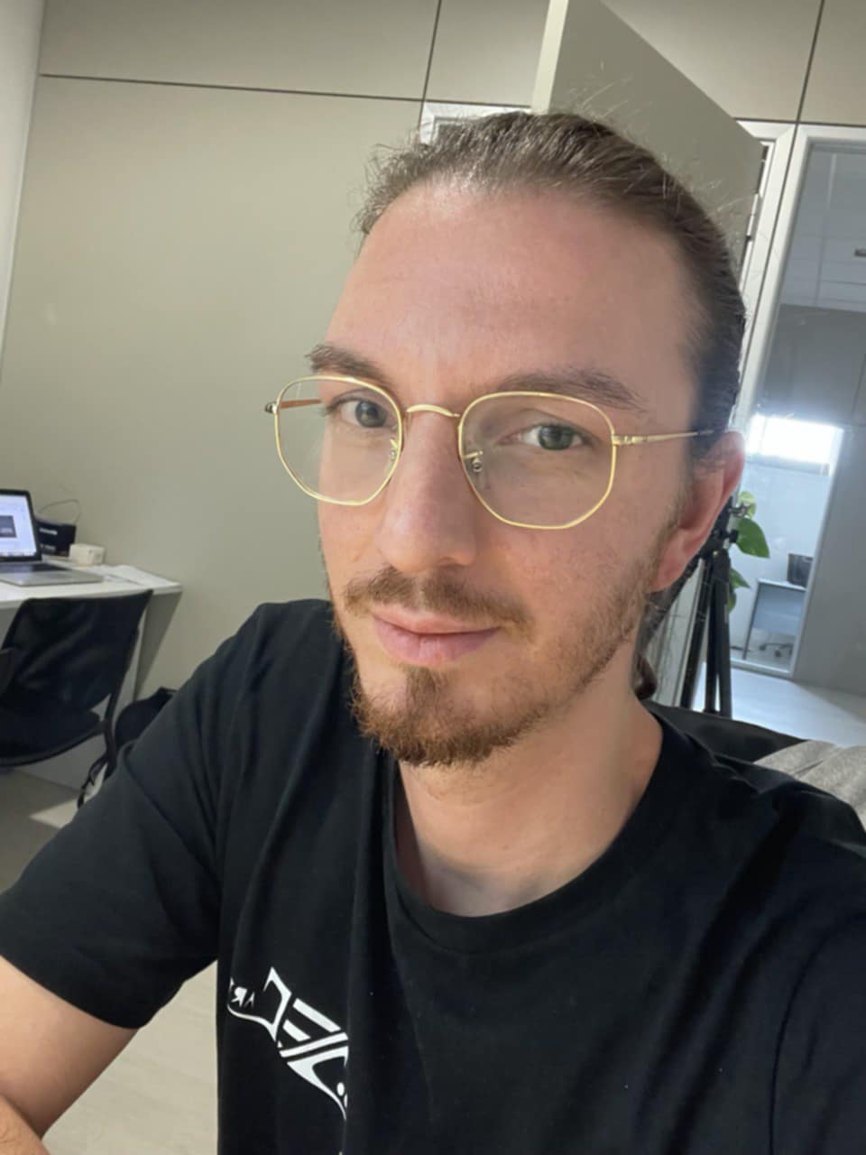 Photo of Davide Edoardo Cassano wearing glasses and a black tshirt.